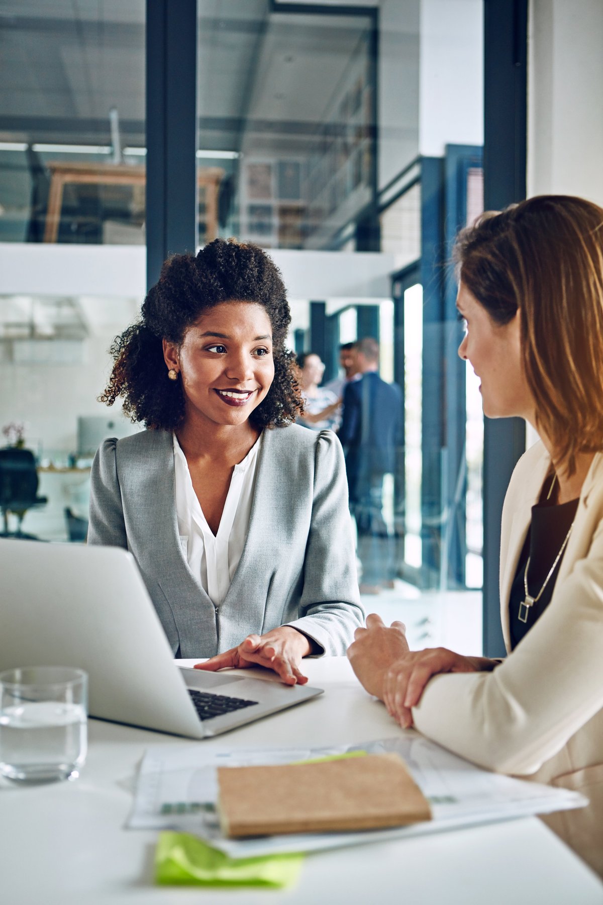 Two corporate businesswomen having a genuine warm discussion in an office, human connection
